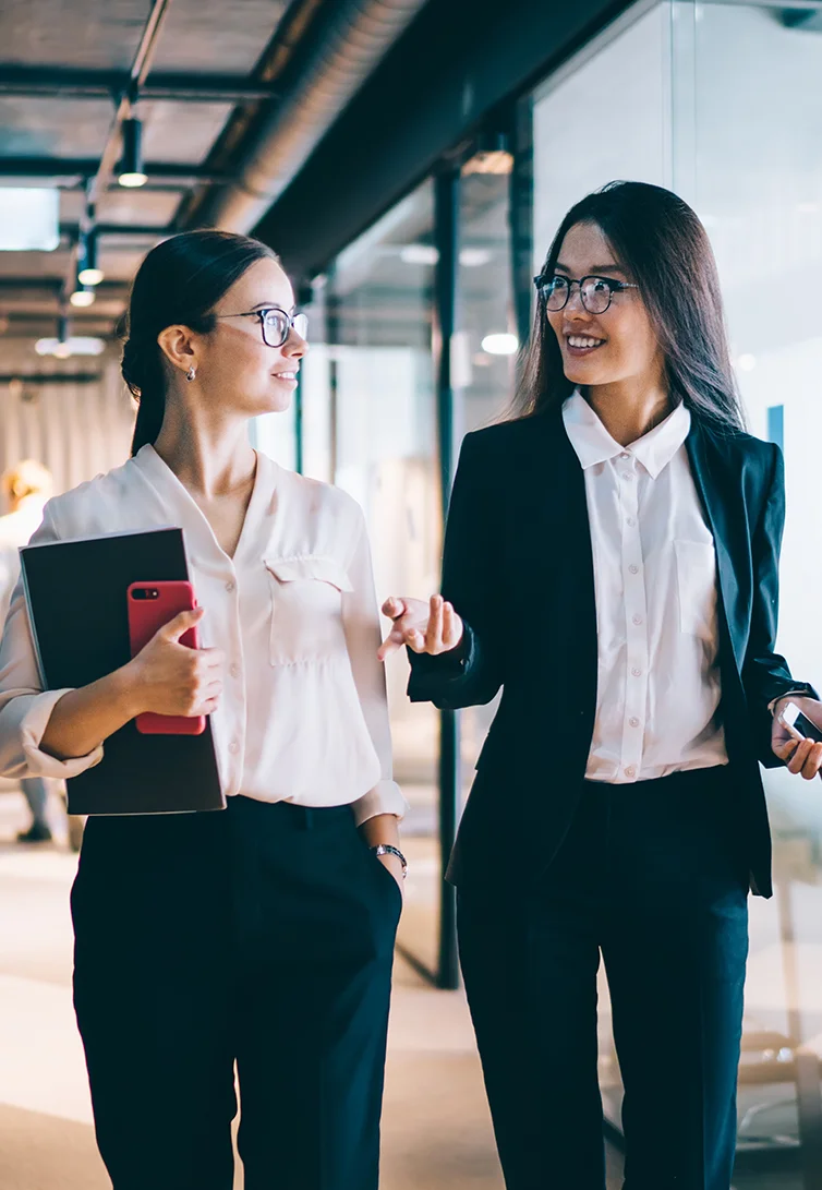 Duas mulheres executivas caminhando no escritório