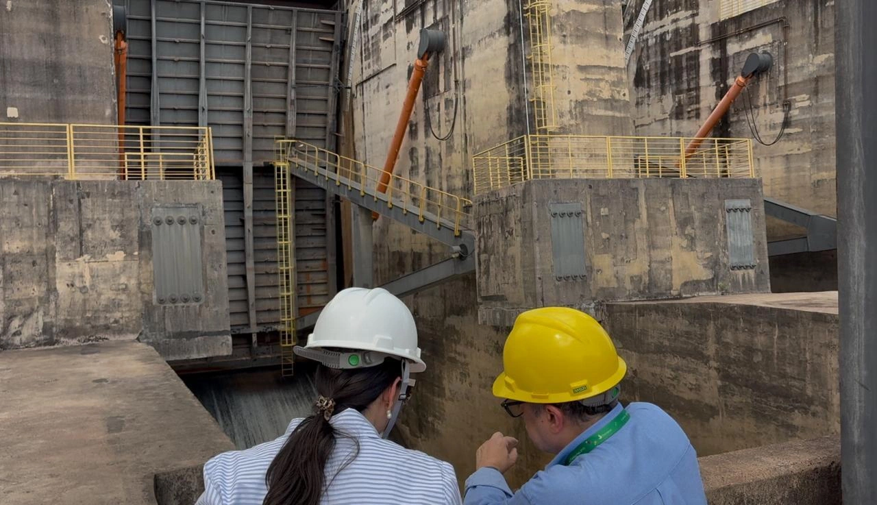 Equipe de engenheiro em frente a uma comporta de vertedouro fechada