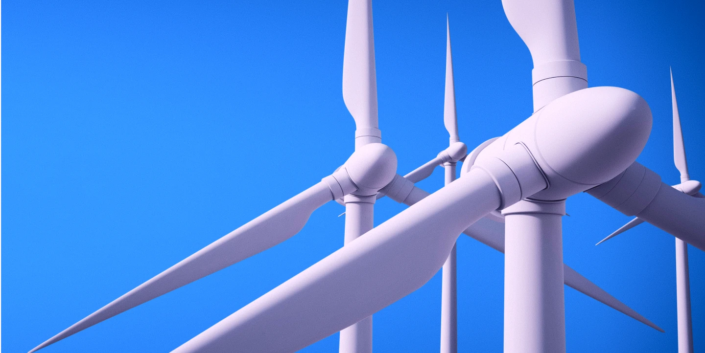 Vista de aerogeradores brancos de energia eólica, com pás em primeiro plano, contra um céu azul.