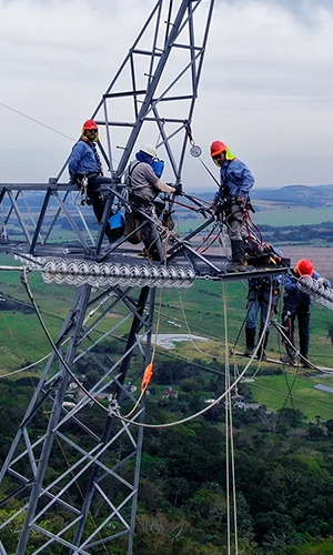 Técnicos trabalhando na linha viva na torre de transmissão