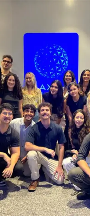 Grupo de estagiários em frente ao logo da AXIA Energia