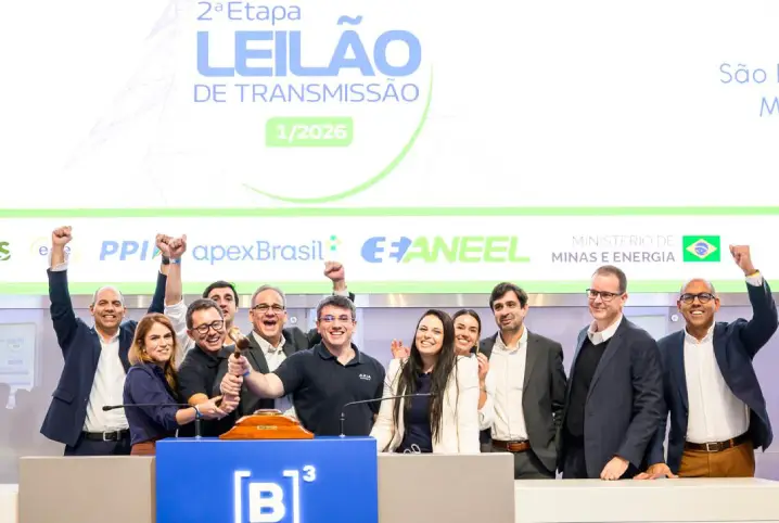 Grupo de profissionais participa da cerimônia do Leilão de Transmissão nº 1/2026 da Aneel, na B3, em São Paulo, reunido ao redor do púlpito após a conquista de lotes de transmissão. Ao fundo, painel com a identificação do evento.
