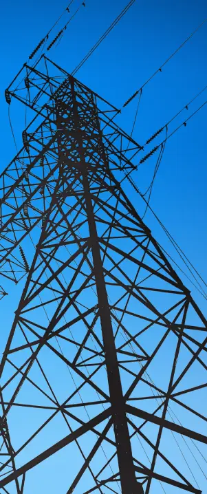 Torre de transmissão de energia com cabos elétricos estendidos, destacando a infraestrutura do sistema elétrico.